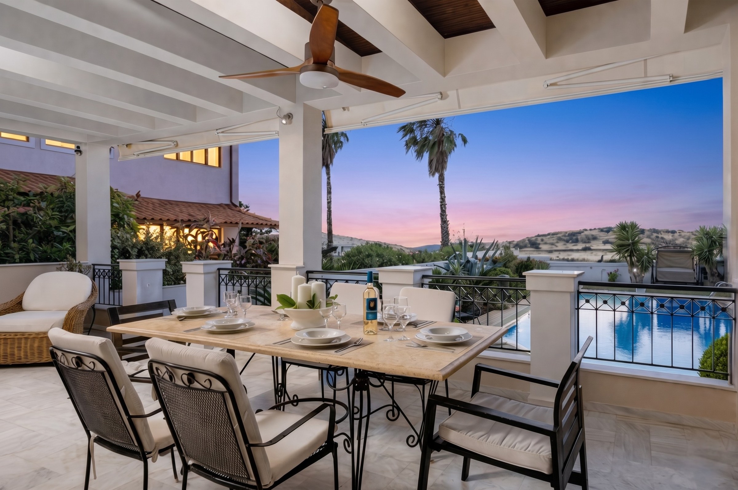 Veranda dining area at twilight with palm trees and Riviera sunset, Renko Royal Villa